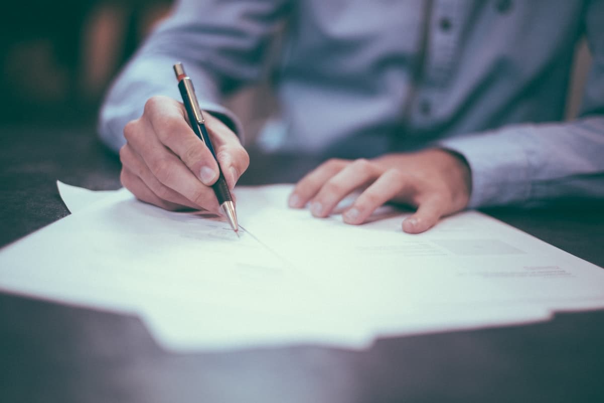 Pen resting on a printed contract — used across several posts.